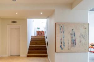 a hallway with stairs and a painting on the wall at Hotel La Mota - BGA Hoteles in Medina del Campo