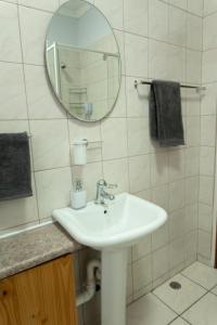 a white bathroom with a sink and a mirror at VillaZek a modern 2 bedroom open- plan apartment with parking in Pretoria