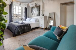 a bedroom with a bed and a blue couch at The Colour House, Kendal Getaway in Kendal