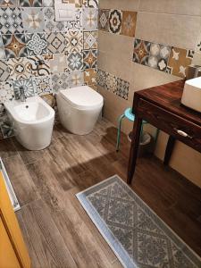 uma casa de banho com lavatório, WC e azulejos em Aromi di casa em Pianella