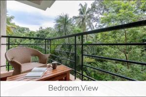 - un balcon avec une table en bois et une chaise dans l'établissement 4BHK Luxury Villa with Private Pool Near Candolim, à Marmagao