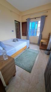 una camera da letto con un letto grande, un tavolo e una televisione di Himalayan Hidden Treasure a Pokhara