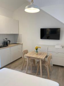 una cocina con mesa de madera y una cocina con armarios blancos. en Blu Riva Hvar, en Hvar