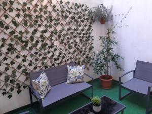 a room with two chairs and a wall with plants at Green Serenity Apartment in Alicante