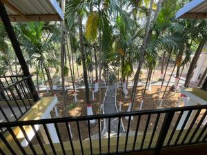 una vista dal balcone di un resort con palme di Riva Gold By Flora Stays ad Alibaug