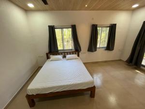una camera con un letto e due finestre di Riva Gold By Flora Stays ad Alibaug