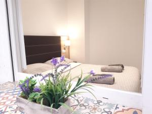 a bedroom with a mirror and a bed with purple flowers at Green Serenity Apartment in Alicante