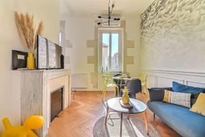 salon z niebieską kanapą i kominkiem w obiekcie Le Yellow - Central - Climatisé w mieście Nîmes