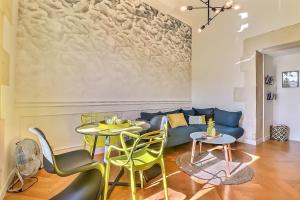 salon z kanapą, stołami i krzesłami w obiekcie Le Yellow - Central - Climatisé w mieście Nîmes