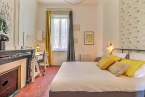 sypialnia z łóżkiem z żółtymi poduszkami i kominkiem w obiekcie Le Yellow - Central - Climatisé w mieście Nîmes