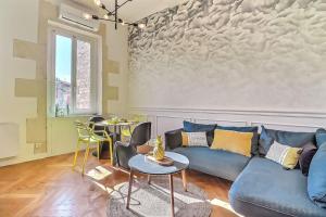 salon z niebieską kanapą i dwoma stołami w obiekcie Le Yellow - Central - Climatisé w mieście Nîmes