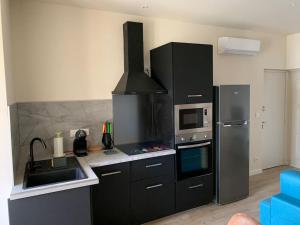 kuchnia z kuchenką i lodówką w obiekcie Appartement rénové vue mer - citadelle de Bastia w Bastii