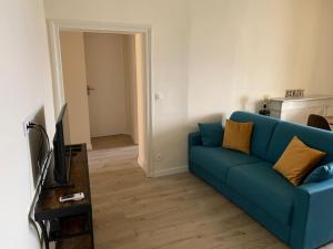 salon z niebieską kanapą i telewizorem w obiekcie Appartement rénové vue mer - citadelle de Bastia w Bastii