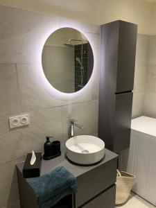 łazienka z umywalką i lustrem w obiekcie Appartement rénové vue mer - citadelle de Bastia w Bastii +9 zdjęć