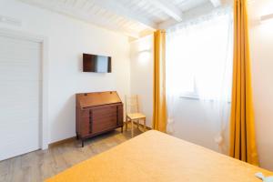 a bedroom with a bed and a dresser and a tv at Agriturismo Torsivì in Castiglione Chiavarese