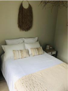 a bed with white sheets and pillows in a bedroom at LE COCOONING 50 m de la plage en baie de somme in Cayeux-sur-Mer