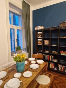stół jadalny z białymi talerzami i kwiatami w obiekcie 4 seasons apartment w Wiedniu