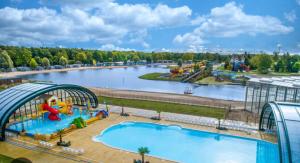 un parque de atracciones con una gran piscina en 9 p bungalow in bossen bij Capfun Stoetenslagh en Rheezerveen