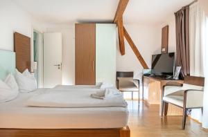 a bedroom with a bed and a desk and a television at Hotel Graf Zeppelin in Konstanz