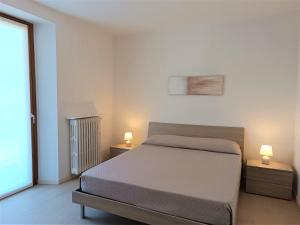 una camera con un letto e due lampade su due tavoli di Winter Spring Summer Apartments a Mergozzo