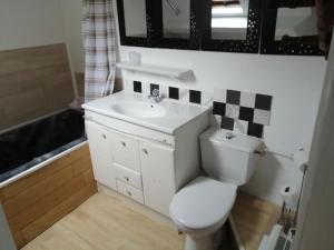 een badkamer met een wit toilet en een wastafel bij Les Fleurs Wimille / Wimereux in Wimille