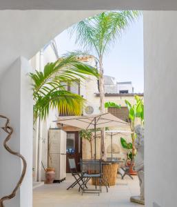 a patio with a table and chairs and palm trees at Casa Celeste in Syracuse