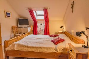 a bedroom with a bed with red curtains and a television at Ferienwohnung Sigrid & Ferdinand BERGINC in Hollenstein an der Ybbs