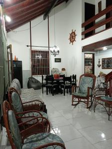 ein Wohnzimmer mit Schaukelstühlen und einem Tisch in der Unterkunft Casa sonho sonhado in São Pedro da Aldeia