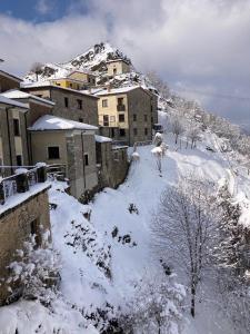 a snow covered city with buildings and a mountain at La torre della manca suite in Sasso di Castalda