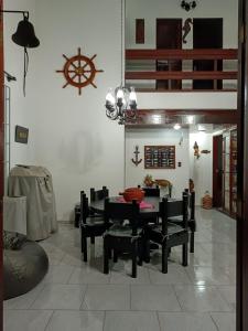 a dining room with a table and black chairs at Casa sonho sonhado in São Pedro da Aldeia