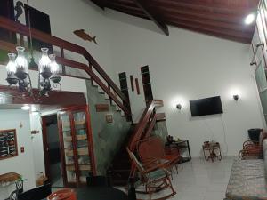 Il comprend un salon avec un escalier et une télévision. dans l'établissement Casa sonho sonhado, à São Pedro da Aldeia