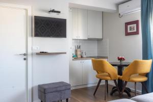 a kitchen with a table and two yellow chairs at Apartment Sovre in Belgrade