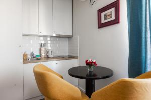 a kitchen with a table and two yellow chairs at Apartment Sovre in Belgrade +30 photos