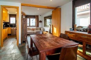 een keuken en een woonkamer met een houten tafel en stoelen bij Port de Llançà 32 Dúplex en 1ª línea de playa in Girona