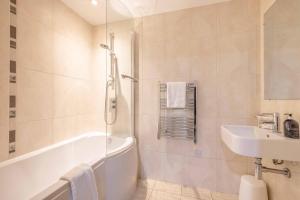 a bathroom with a bath tub and a sink at 2 BED AT SLOUGH STATION & PARKING - LONDON IN 20 MINS in Slough