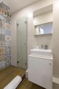 ein weißes Bad mit einem Waschbecken und einer Dusche in der Unterkunft Apartment Sovre in Belgrad