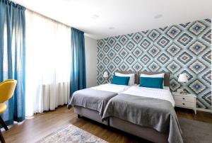 een slaapkamer met een bed met blauwe muren en blauwe gordijnen bij Apartment Sovre in Belgrado