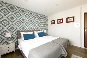 a bedroom with a bed with a blue accent wall at Apartment Sovre in Belgrade