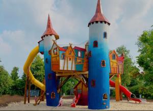 un parque infantil con una zona de juegos de castillo en un parque en 9 p bungalow in bossen bij Capfun Stoetenslagh en Rheezerveen
