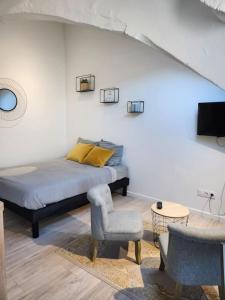 - une chambre avec un lit, une chaise et une télévision dans l'établissement Le Yellow Korner - lit neuf, à Rouen