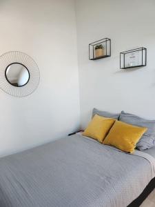 - une chambre avec un lit et un miroir mural dans l'établissement Le Yellow Korner - lit neuf, à Rouen