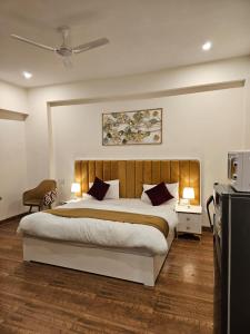 um quarto com uma cama grande e uma televisão em Amahi Inn em Gurgaon