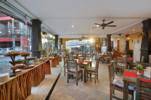 una sala da pranzo con tavoli e sedie e un ristorante di Royal Tunjung Hotel & Villa Legian - CHSE Certified a Legian