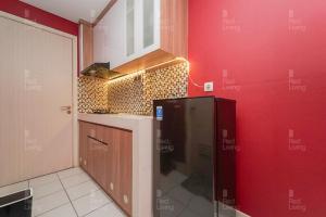 - une cuisine avec un réfrigérateur noir dans un mur rouge dans l'établissement RedLiving Apartemen Patra Land Urbano - Kamarku Tower Mid-West, à Bekasi