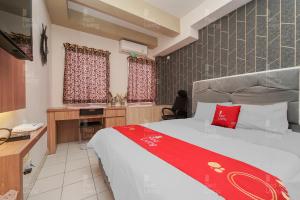 - une chambre avec un lit et un bureau dans l'établissement RedLiving Apartemen Patra Land Urbano - Kamarku Tower Mid-West, à Bekasi