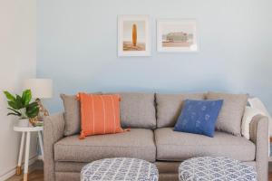 a living room with a gray couch with orange and blue pillows at 9 Palms in Myrtle Beach