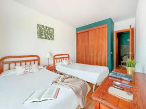 Un dormitorio con 2 camas y una mesa con un libro. en Apartamentos Laguna, en Puerto Rico de Gran Canaria