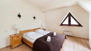 a bedroom with a bed and a triangle sign on the wall at Apartamenty Sun & Snow Pacyfik Spa z basenem in Kościelisko