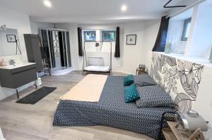 - une chambre avec un lit doté d'oreillers bleus et d'un lavabo dans l'établissement Côté Jards, à Châlons-en-Champagne