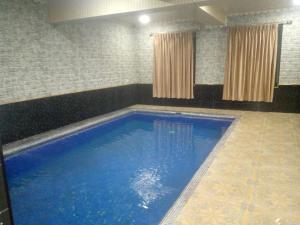 a large blue swimming pool in a room at Гостевой дом Нилюфар in Kyzyldzhar